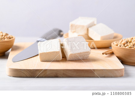 Fresh tofu on cutting wooden board, Vegan food ingredient in Asian cuisine, Plant based diet 110800385