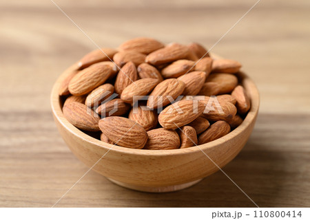 Raw almond in bowl on wooden background Raw almond in bowl on wooden background 110800414
