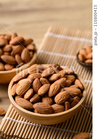 Raw almond in bowl on wooden background Raw almond in bowl on wooden background 110800415