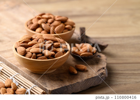 Raw almond in bowl on wooden background Raw almond in bowl on wooden background 110800416