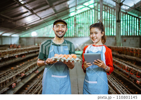 Male and female entrepreneur carrying egg tray and holding tablet Male and female entrepreneur carrying egg tray and holding tablet 110801145