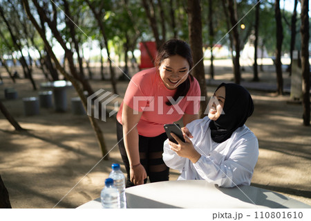 asian women in sportswear taking break after exercise 110801610