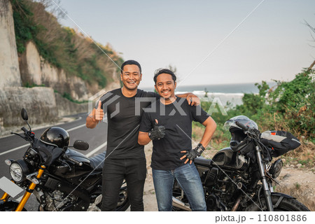 asian rider hungging friend with thumb up gesture asian rider hungging friend with thumb up gesture 110801886