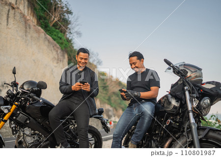 happy indonesian riders watching phone together 110801987