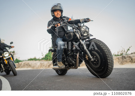 asian motorcyclist on jacket and helmet traveling 110802076