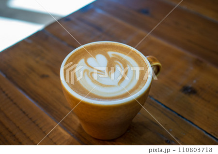 木目のテーブルに置かれたラテに描かれたラテアート 110803718