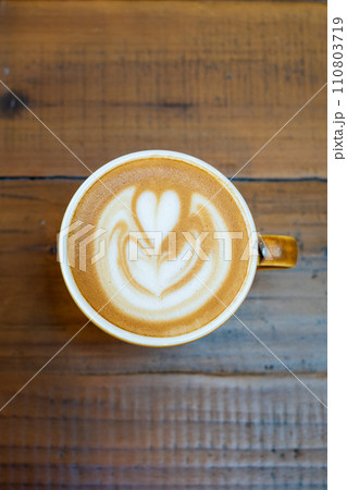 木目のテーブルに置かれたラテに描かれたラテアート 110803719