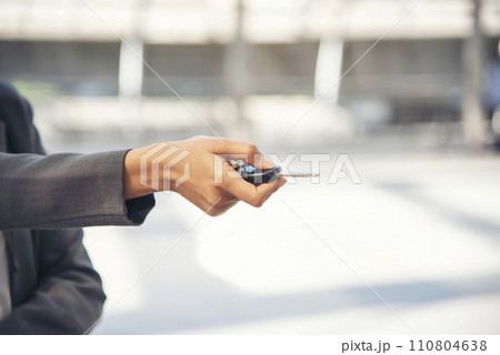 Women Hands using remote control car key. Close up hands of young woman showing key of new car. Businesswoman smile holding car rental key. Women driver giving car service safety drive. 110804638