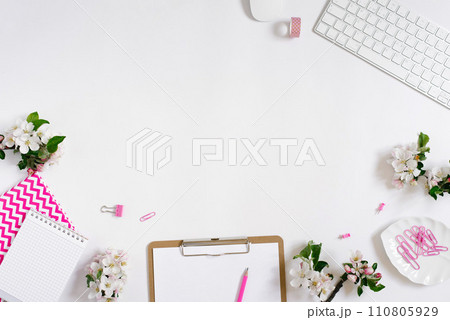 Flat lay home office workspace female blogger background with white modern keyboard, notebook and apple flowers, copy space on white background 110805929
