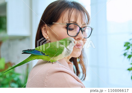Close-up of green parrot on the shoulder of a female owner 110806617