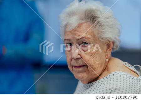 Portrait of scared senior patient on examination table in the hospital. Concept of fear and anxiety about health problems in elderly people. 110807790