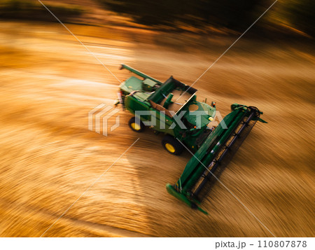 Aerial view of a harvester working in a field. Agriculture and cultivation of industrial farms. Agribusiness. Aerial view of a harvester working in a field. Agriculture and cultivation of industrial farms. Agribusiness. 110807878