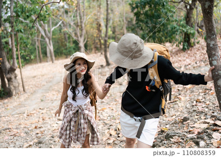Happy LGBT Lesbian couple Travelers Hiking with Backpacks in forest Trail. LGBT Lesbian Couple Hikers with backpacks walks in mountains in vacation 110808359