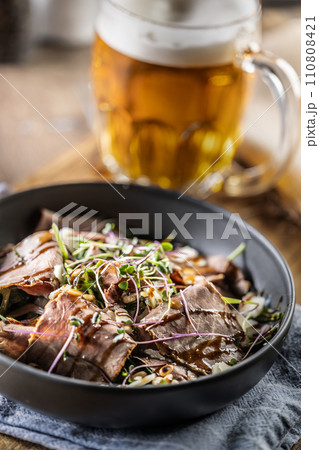 Roast beef salad with herbs and balsamic sauce in the style of a bowl on a restaurant table 110808421