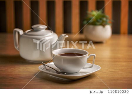 Herbal tea with white tea cup and teapot Herbal tea with white tea cup and teapot 110810080