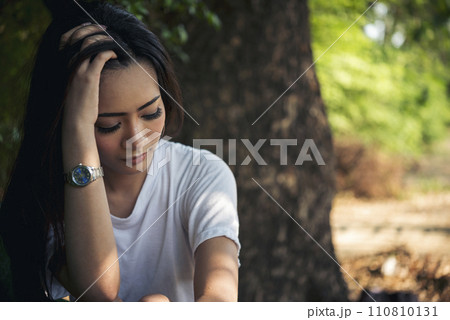 Recession Stress Woman using laptop work hard at home office outdoor in green park. Young women have headache, depressed from failure business burnout. Tired Asian woman despair sadness problems 110810131