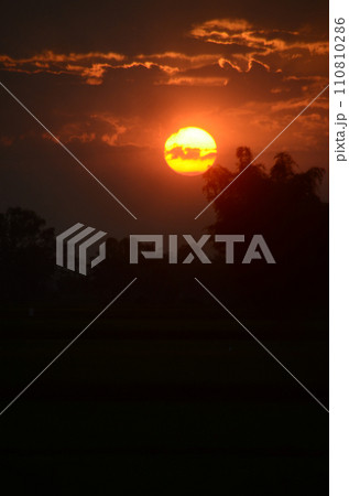Scenic view dramatic beautiful sunset sky. Natural Sunset Sunrise on meadow silhouette shadow dark land. Vibrant dramatic sky on sunset, dawn, sunrise in Countryside. Landscape Colorful Sky At Sunset Scenic view dramatic beautiful sunset sky. Natural Sunset Sunrise on meadow silhouette shadow dark land. Vibrant dramatic sky on sunset, dawn, sunrise in Countryside. Landscape Colorful Sky At Sunset 110810286