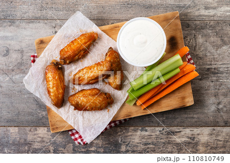 Buffalo spicy chicken wings with cayenne pepper sauce on wooden table 110810749