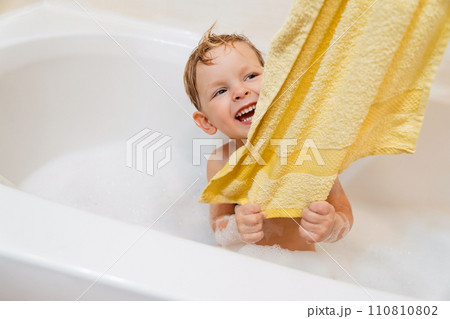 A cheerful little boy having fun in the bubble bath 110810802