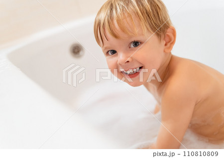 Cute baby boy in bathtub. Happy child taking bath. 110810809