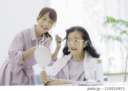 自宅で訪問ヘアカットを受けるシニア女性 110810953