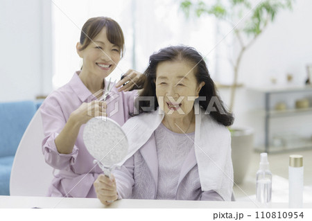 自宅で訪問ヘアカットを受けるシニア女性 110810954