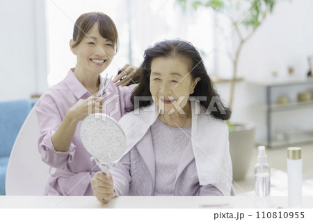 自宅で訪問ヘアカットを受けるシニア女性 110810955
