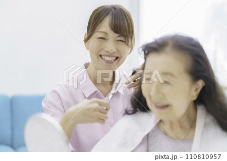 自宅で訪問ヘアカットを受けるシニア女性 自宅で訪問ヘアカットを受けるシニア女性 110810957