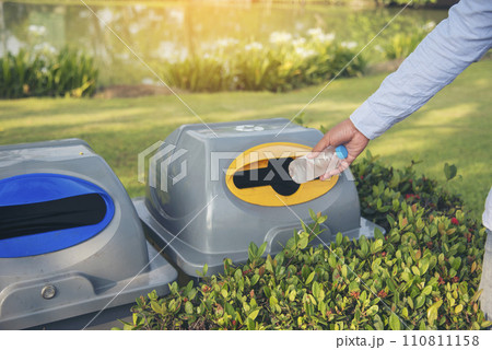 Men hands trow Trash cans for sorting garbage recycle bin waste plastic container collection. Reuse, reduce, recycle sorting process sustainable lifestyle rubbish dustbin plastic box in green garden 110811158