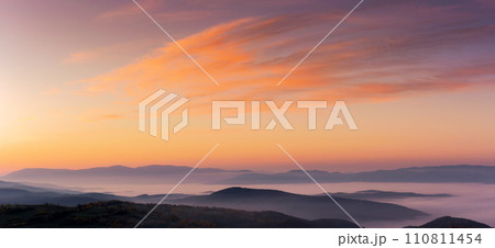 panorama of a sky above the carpathian mountain range with fog in the valley at dawn. clouds in red and orange colors of a rising sun 110811454