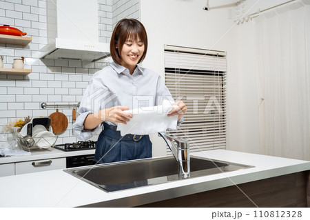 キッチンで拭き掃除をする女性 110812328