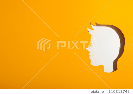 A child's head made of paper on a yellow background A child's head made of paper on a yellow background 110812742