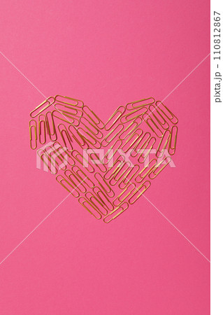 Heart from paper clips, on a red background. 110812867