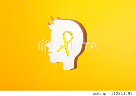A child's head made of white paper with a yellow ribbon 110813399