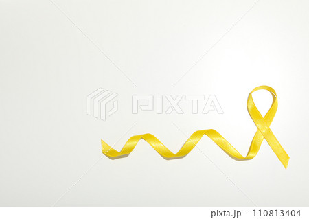 Yellow satin ribbon on a white background 110813404
