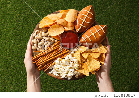 A bowl with various beer snacks on the grass A bowl with various beer snacks on the grass 110813917