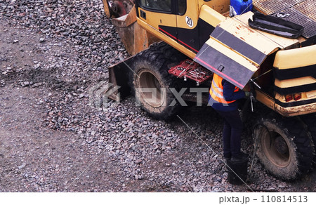 Kiev, Ukraine March 13, 2019: Workers repair equipment on the construction of the zero cycle foundation of the entertainment center Kiev, Ukraine March 13, 2019: Workers repair equipment on the construction of the zero cycle foundation of the entertainment center 110814513