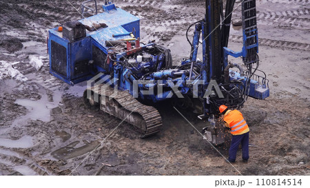 Kiev, Ukraine March 13, 2019: Workers repair equipment on the construction of the zero cycle foundation of the entertainment center Kiev, Ukraine March 13, 2019: Workers repair equipment on the construction of the zero cycle foundation of the entertainment center 110814514