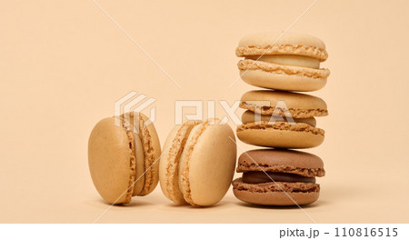 Chocolate macarons on a beige background, a stack of dessert Chocolate macarons on a beige background, a stack of dessert 110816515