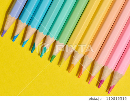 Multi-colored wooden pencils on a yellow background, top view Multi-colored wooden pencils on a yellow background, top view 110816516