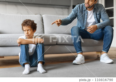 Angry african american father scolding upset little son at home Angry african american father scolding upset little son at home 110816790