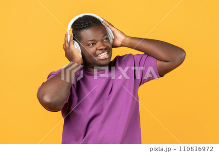 Cheerful Black Man Wearing Wireless Headphones Listens To Song, Studio 110816972