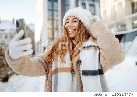 Young woman taking selfie in winter street. Holidays, rest, blogging. 110818477