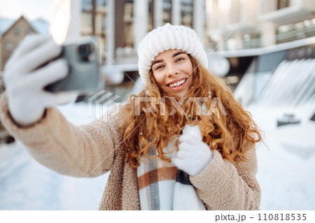 Young woman taking selfie in winter street. Holidays, rest, blogging. 110818535
