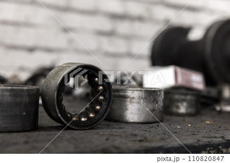 Old used bearings on a desk in a car repair shop, close up Old used bearings on a desk in a car repair shop, close up 110820847
