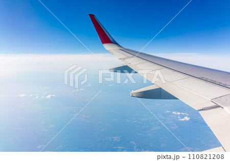 View from the airplane window at a beautiful cloudy sky and the airplane wing View from the airplane window at a beautiful cloudy sky and the airplane wing 110821208