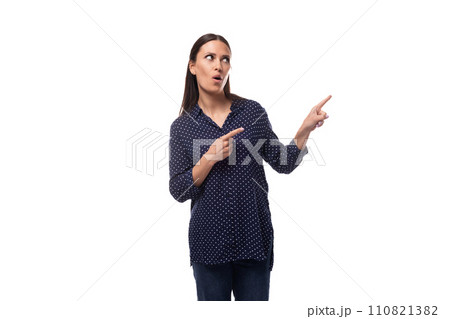 a young woman with black hair dressed in a blue blouse looks away and points her finger a young woman with black hair dressed in a blue blouse looks away and points her finger 110821382