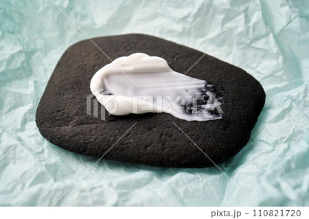A smear of white cream on a black stone. A smear of white cream on a black stone. 110821720