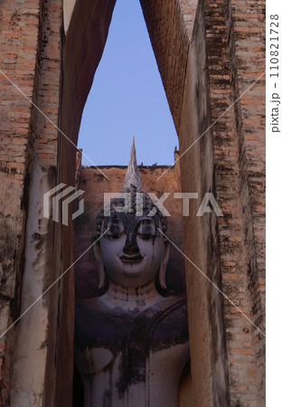The buddha in Wat Si Chum in Sukhothai Historical Park, pagoda stupa, Sukhothai, Thailand. Thai buddhist temple architecture. Tourist attraction. The buddha in Wat Si Chum in Sukhothai Historical Park, pagoda stupa, Sukhothai, Thailand. Thai buddhist temple architecture. Tourist attraction. 110821728