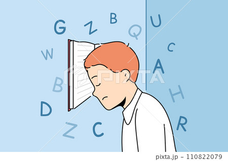 Boy with school textbook, tired due to grueling lessons, stands with head resting on book 110822079